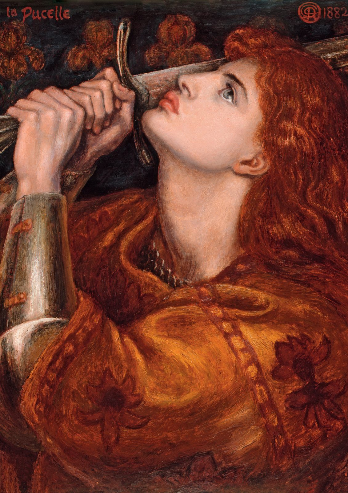 Joan of Arc by Dante Gabriel Rossetti, 1882. A woman with long red hair in armour kisses the blade of a sword held upright before her face.